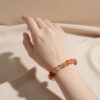 A woman wearing the Arie Zodiac crystal energy bracelet, showing how it looks on the wrist.