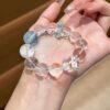 A woman wearing the Cancer Zodiac crystal energy bracelet, showing how it looks on the wrist.