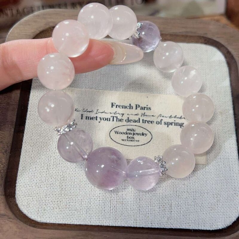 A close-up detail shot of the Rose quartz crystal bead on the Piscess Zodiac.