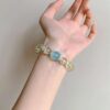 A woman wearing the Sagittarius Zodiac crystal energy bracelet, showing how it looks on the wrist.