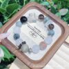 A close-up detail shot of the green rutilated quartz crystal bead on the Chinese DogZodiac.