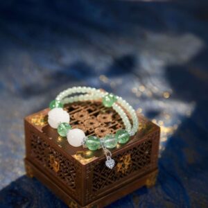A Chinese Goat Zodiac crystal bracelet with green rutilated and phantom quartz beads.