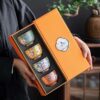An ornate enameled handmade ceramic teacup shown nestled in its elegant and protective gift box, perfect for gifting.