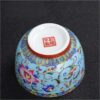 The imperial detailed Interlocking Lotus enameled handmade ceramic teacup, showcasing intricate pink and white lotus flowers.