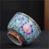 The imperial detailed Interlocking Lotus enameled handmade ceramic teacup, showcasing intricate pink and white lotus flowers.