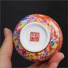 The imperial detailed Interlocking Lotus enameled handmade ceramic teacup, showcasing intricate pink and white lotus flowers.