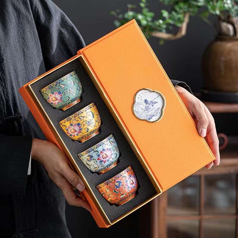 An ornate enameled handmade ceramic teacup shown nestled in its elegant and protective gift box, perfect for gifting.