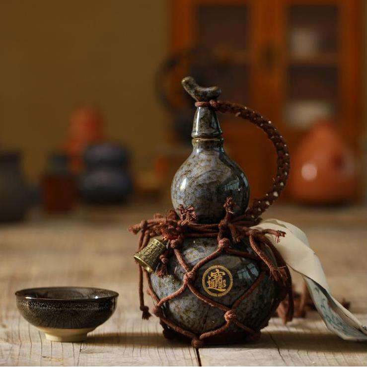 The artisanal ceramic gourd water bottle presented in black color.
