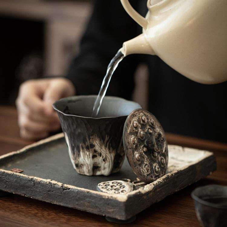 A beautifully sculpted Lotus Flower ceramic tea tray with a textured, dark glaze, designed as part of a Kung Fu tea set.
