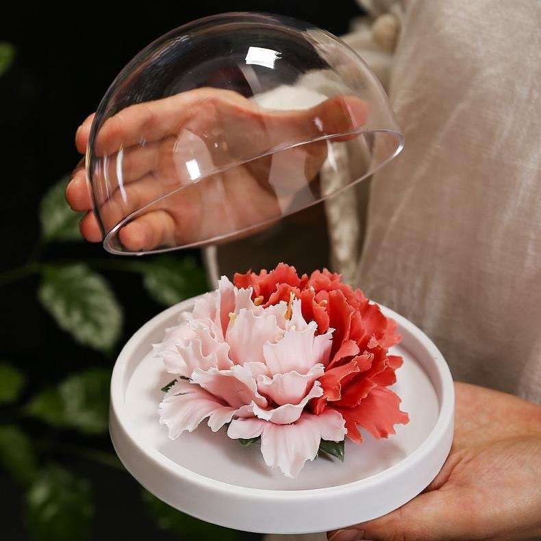 A beautiful handmade flower ceramic diffuser inside the transparent cover.