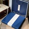 An elegant, open Handmade Suzhou Embroidery Silk Gift Box displaying its contents: a hand-embroidered silk scarf, an ebony hairpin, a pearl necklace, and an enamel brooch.