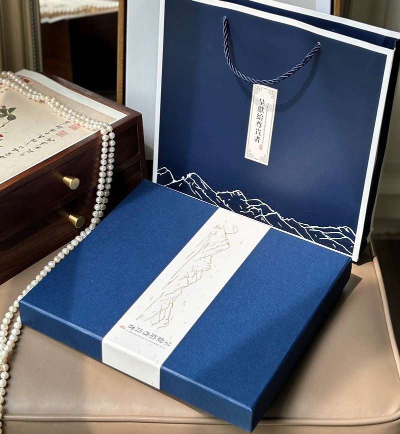 An elegant, open Handmade Suzhou Embroidery Silk Gift Box displaying its contents: a hand-embroidered silk scarf, an ebony hairpin, a pearl necklace, and an enamel brooch.