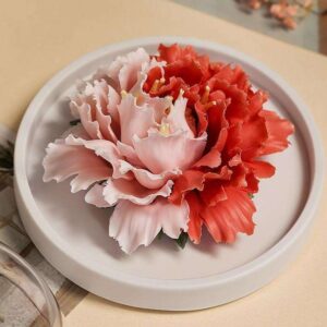 A close-up detail shot of the delicate, hand-sculpted petals on the porous porcelain peony flower aromatherapy diffuser.