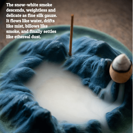The mesmerizing smoke waterfall effect of the backflow incense burner, with thick, milky smoke pooling in the valleys of the mountain design.