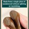 A macro shot highlighting the beautiful, unique natural wood grain and color variations of the green sandalwood comb scalp tool.