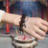 A woman wearing the Wu Earth crystal energy bracelet, showing how it looks on the wrist.