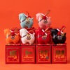 Close up of a red year of the horse ceramic ornament showing the golden coin detail, greeting scroll, and glossy porcelain finish for Lunar New Year decoration.