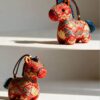 Collection of Handmade Brocade Guardian Horse Embroidery Amulet charms in pink, black, and other colors, hanging together to show the variety of Lunar New Year gifts.
