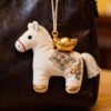 Collection of Handmade Brocade Guardian Horse Embroidery Amulet charms in pink, black, and other colors, hanging together to show the variety of Lunar New Year gifts.