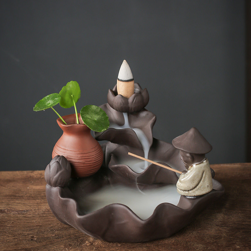 Ceramic Backflow Incense Burner Fishing Alone style featuring a fisherman figure, a smoke waterfall, and a small green plant in a vase.