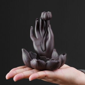 Close up of the smoke waterfall effect flowing down the Buddha hand backflow incense burner from a lit cone.