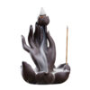 Close up of the smoke waterfall effect flowing down the Buddha hand backflow incense burner from a lit cone.