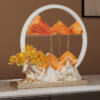 Elegant Feng Shui Moving Sand Art placed on a modern console table, showcasing the golden sand forming a mountain backing for the fortune deer statues.